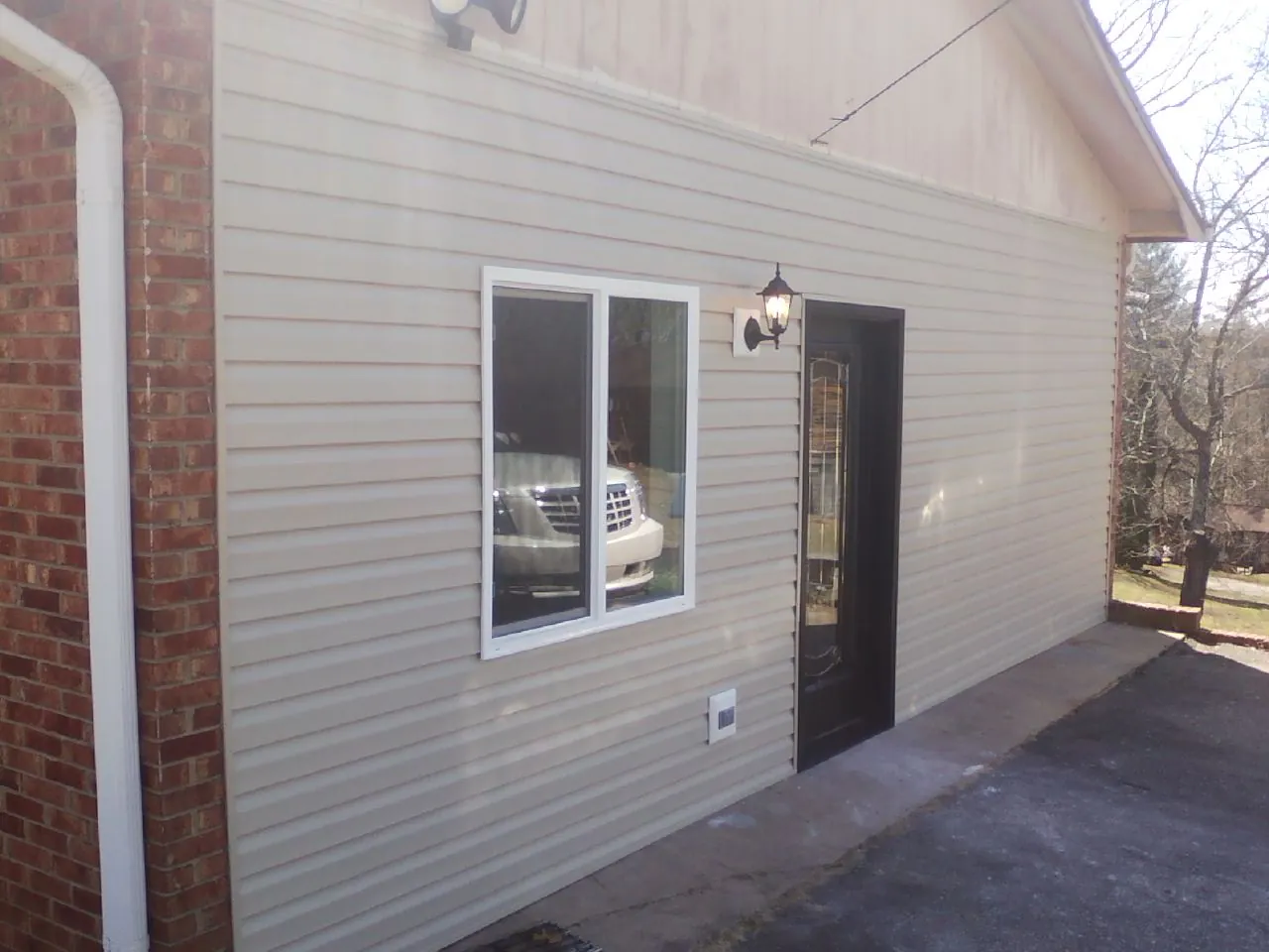New vinyl siding and entry door on a room addition in Worth