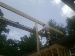 Carpenter setting a ridge beam over a new addition frame — Ice Dam Removal by Roofing Brothers in Worth