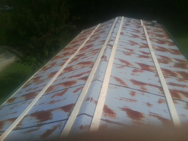 Rusted metal roof panels with new wood purlins before replacement — Storm Damage Roof Repair in Worth by Roofing Brothers