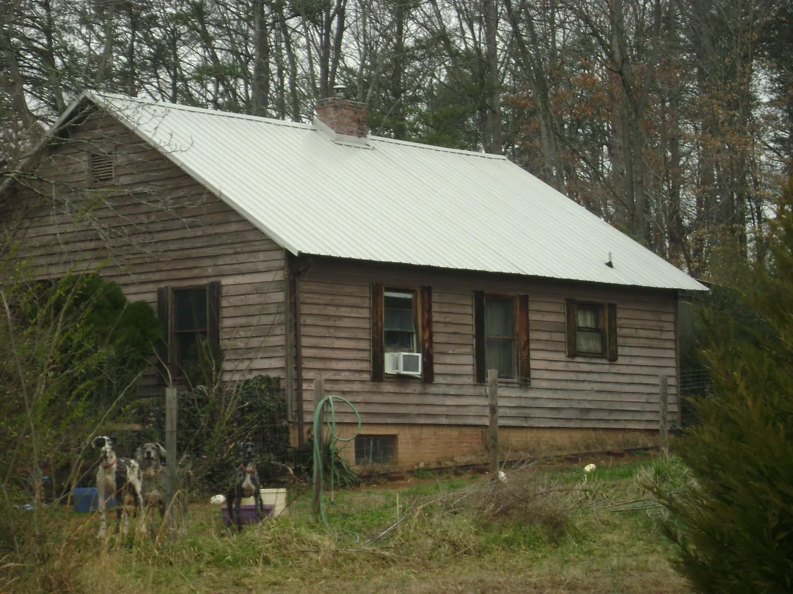 White metal roof on an old wood sided farmhouse, from a Metal Roof Installation job in Worth